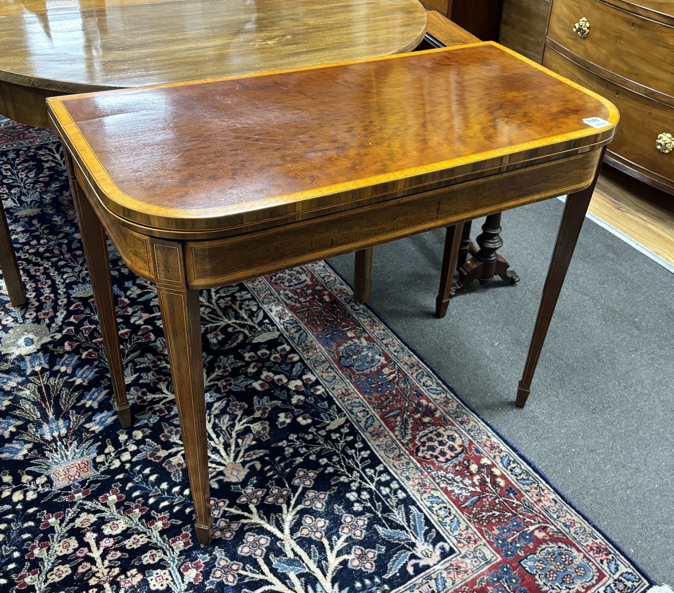 A George III satinwood banded mahogany D shape folding card table, width 94cm, depth 46cm, height 75cm